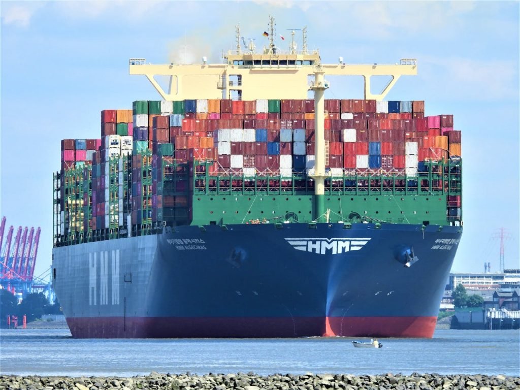 Front view of a massive cargo ship loaded with containers in Hamburgs harbor.